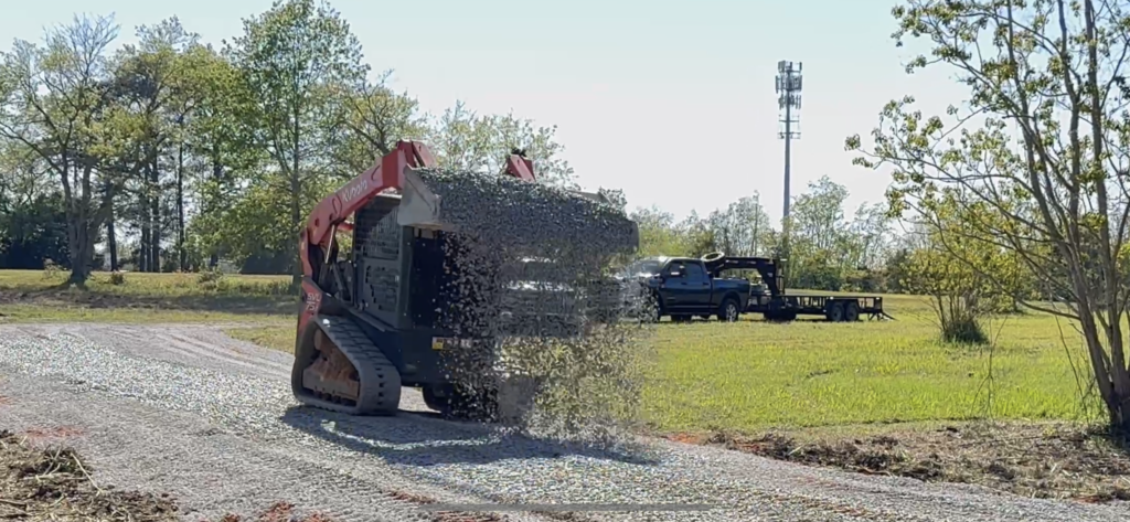 A skid steer loader pouring gravel.